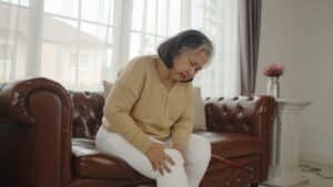 Older woman holding her leg in pain from DVT symptoms in Portland, OR